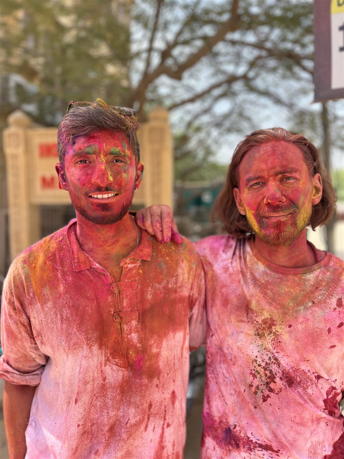 Dos integrantes de Hola Travel durante una celebración llena de colores